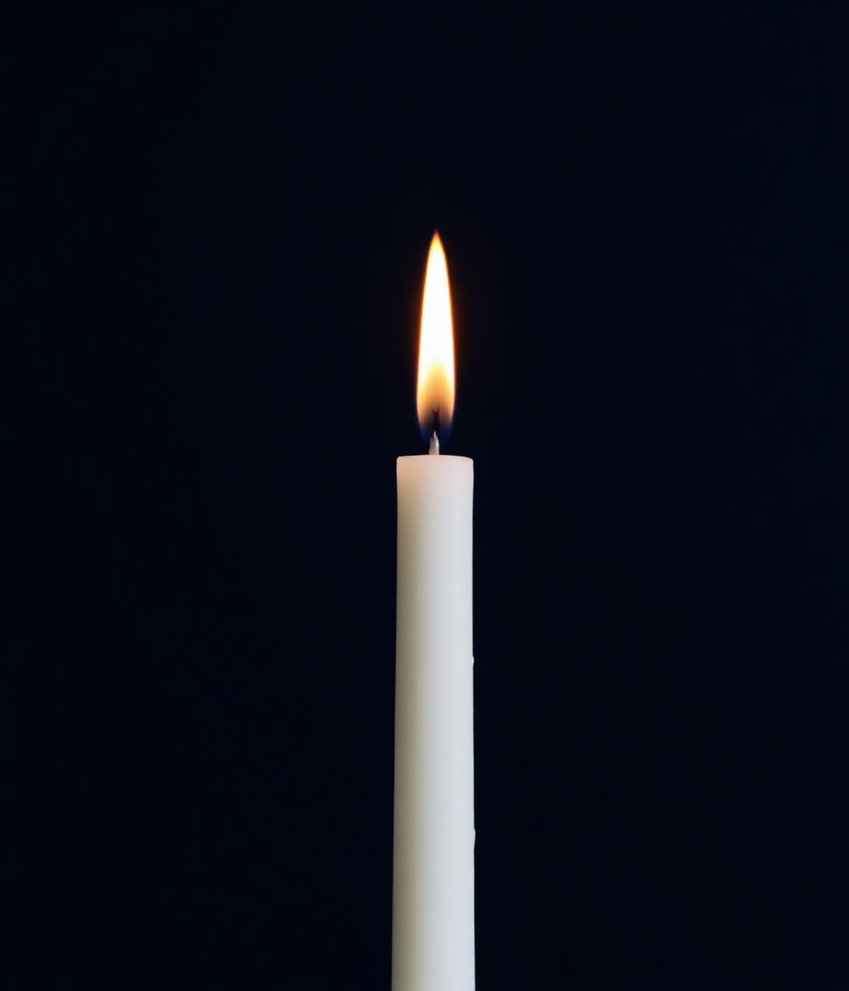 A single lit taper candle against a dark background